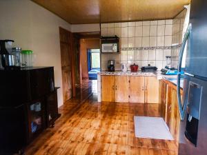 a large kitchen with wooden floors and a refrigerator at Amphibia House in Agua Azul