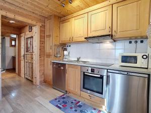 a kitchen with stainless steel appliances and wooden cabinets at Appartement cosy 4 pers à La Clusaz, Wifi, Animaux admis - FR-1-818-36 in La Clusaz