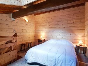 a bedroom with a bed in a wooden cabin at La Clusaz: Duplex 4 pers, Animaux admis, Parking réservé - FR-1-818-90 in La Clusaz