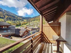 a balcony with a view of a town and mountains at La Clusaz: Duplex 4 pers, Animaux admis, Parking réservé - FR-1-818-90 in La Clusaz +2 photos