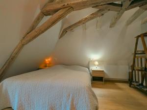 a bedroom with a white bed in the attic at Gîte charmant avec parking, animaux acceptés, près du Château de Clavières - FR-1-591-718 in Ardentes