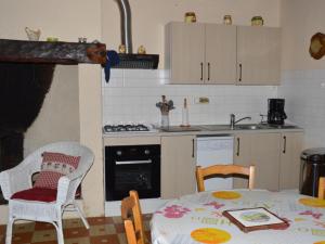 a kitchen with a table and chairs and a kitchen with a stove at Charmante maison nature avec parking et animaux acceptés - FR-1-616-459 in Pézuls +5 photos