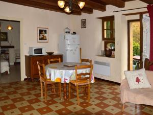 a kitchen with a table and chairs and a refrigerator at Charmante maison nature avec parking et animaux acceptés - FR-1-616-459 in Pézuls