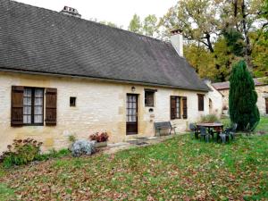 an old white house with a picnic table in the yard at Charmante maison nature avec parking et animaux acceptés - FR-1-616-459 in Pézuls
