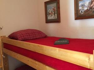 - une chambre avec un lit doté d'un cadre en bois et d'un matelas rouge dans l'établissement 2 Pièces + Coin Montagne, Cheminée, Parking, Wi-Fi - 4 Pers. - FR-1-762-54, au Monêtier-les-Bains