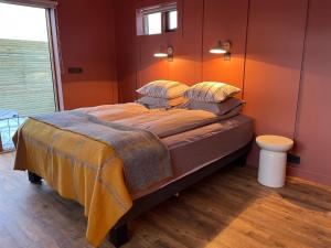 a bedroom with a large bed with orange walls at Skard Cottages in Fludir