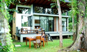 two people sitting at a table in front of a house at Sakuna Arana Resort in Bentota