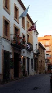 a building with flags on the side of a street at Hotel Triskel in Jávea