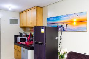 een keuken met een koelkast en een magnetron bij Affordable Up To 13 Guest JOSHUA Near Aqua Planet & SM City Clark in Angeles