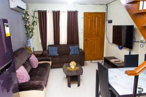 een woonkamer met een bank en een tafel bij Affordable Up To 13 Guest JOSHUA Near Aqua Planet & SM City Clark in Angeles