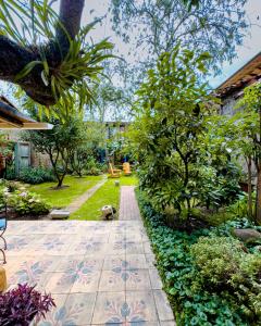a garden with a pathway and trees and plants at Hotel Boutique Casa Montalvo Cuenca in Cuenca