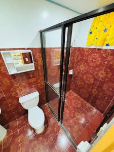 a bathroom with a toilet and a shower at BELLAVISTA de boracay GUEST HOUSE in Boracay