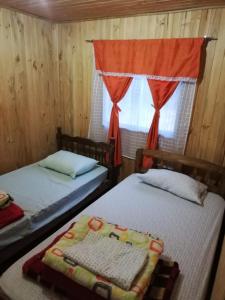 モリーナにあるCabañas El Toro - Radal Siete Tazasの窓のある部屋にベッドが2つある