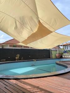 a large yellow umbrella over a swimming pool at Villabay Teluk Mak Nik Kemaman in Cukai