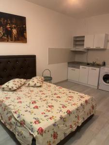 a bedroom with a bed with a floral bedspread at RIN Grand Residence in Bucharest