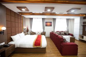 um quarto de hotel com uma cama e um sofá em Hotel Ambrosia, Charikot, dolakha em Charikot