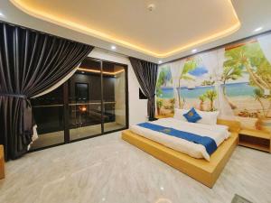 a bedroom with a bed with a painting of a beach at Phuong Linh Hotel - Ninh Thuận in Phan Rang–Tháp Chàm