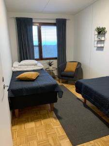 a bedroom with two beds and a chair at Cozy 2BR Apartment KA64 with sauna in Oulu