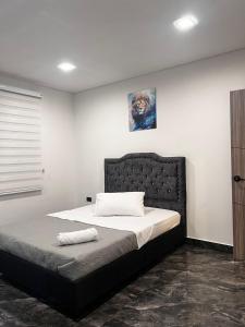 a bedroom with a large bed with a black headboard at Quinta Emmanuel in Guaduas