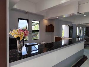 a kitchen with a vase of flowers on a counter at RedDoorz at Pilgrims Hotel in Bulatok