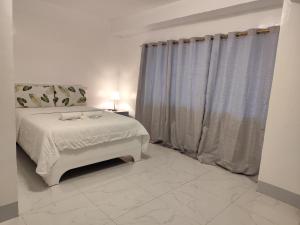 BulatokRedDoorz at Pilgrims Hotel的一间带床和窗户的白色卧室