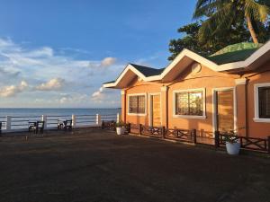 a house on the beach with the ocean behind it at Japitan Waterfront Resort in Dolores