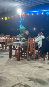 a man and a woman sitting at a table at Duong Riverside Homestay in Phong Nha
