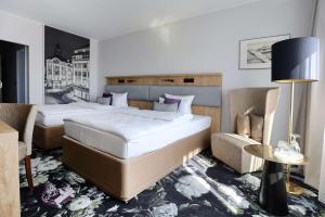 a hotel room with two beds and a chair at Best Western Hotel Windorf in Leipzig +39 photos