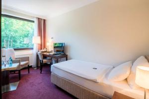 a hotel room with a bed and a desk with a computer at Best Western Hotel Hamburg International in Hamburg +40 photos