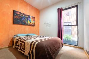 a bedroom with a bed with a painting on the wall at Bello y económico departamento in Mexico City