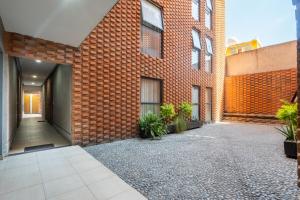 an empty courtyard of a brick building with plants at Bello y económico departamento in Mexico City