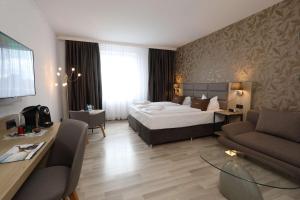 a hotel room with a bed and a couch at Best Western Hotel Rosenau in Bad Nauheim