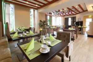 a dining room with tables and chairs with green napkins at Best Western Hotel Rosenau in Bad Nauheim