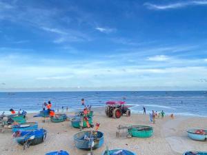 a group of people on a beach with boats at Homestay-Phước Hải in Chợ Phước Hải