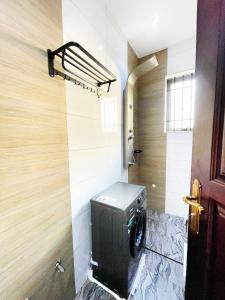 a washer and dryer in a bathroom with a door at Sn Suites apartment in Kampala