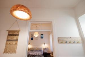 a bedroom with a bed and a light fixture at Cozy Beach House in Ribeira Grande