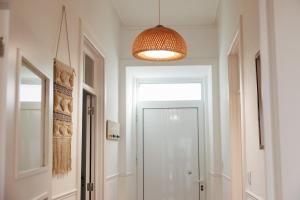 a hallway with a white door and a pendant light at Cozy Beach House in Ribeira Grande +34 photos