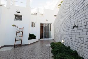 a white house with a brick wall at Cozy Beach House in Ribeira Grande