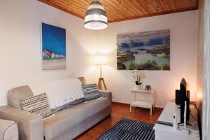 a living room with a couch and a tv at Cozy Beach House in Ribeira Grande