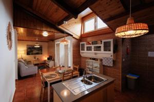 a kitchen with a sink and a table in a room at Cozy Beach House in Ribeira Grande