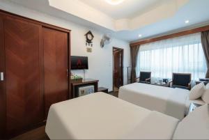 a hotel room with two beds and a desk at A25 Hotel - 221 Bạch Mai in Hanoi +18 photos