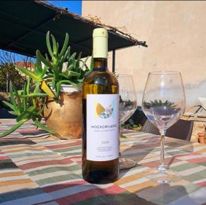 a bottle of wine sitting on a table with two glasses at Compass in Kavála