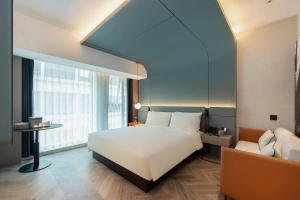 a bedroom with a large white bed and a couch at Atour Hotel Xi'an Qujiang Creative Valley in Xi'an