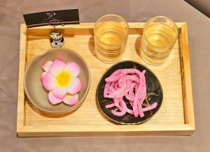 un vassoio con un piatto di cibo e due bicchieri d'acqua di Pink Boutique Ben Thanh Hotel ad Ho Chi Minh