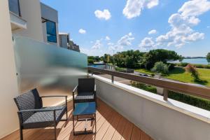 two chairs on a balcony with a view of the water at Logis Hôtel Le Rochelois in La Rochelle