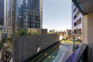 a swimming pool on top of a building with tall buildings at Luxury apartment free car park, pool, gym, Sauna, steam room in Melbourne