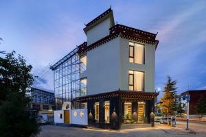 ein hohes weißes Gebäude mit einer Uhr darauf in der Unterkunft Shangri La Anyu Garden Resort Hotel in Shangri-La