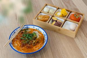 eine Schüssel Suppe und eine Holzkiste Essen in der Unterkunft Shangri La Anyu Garden Resort Hotel in Shangri-La