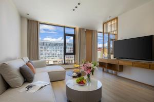 ein Wohnzimmer mit Couch und Flachbildfernseher in der Unterkunft Shangri La Anyu Garden Resort Hotel in Shangri-La