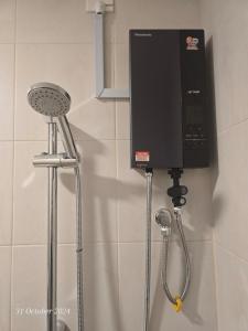 a shower head and a phone on a wall at Sensory Southville Bangi Lux Condo in Kajang